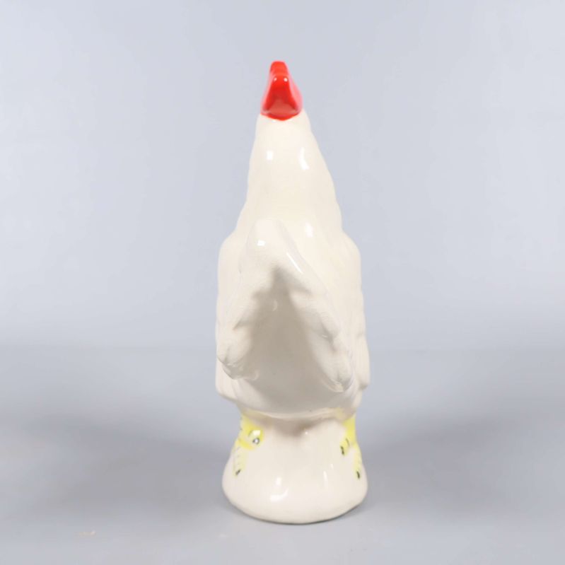 Keramisk tuppfigur sedd bakifrån