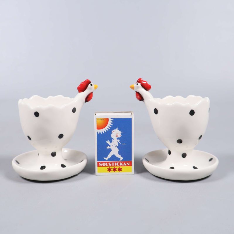 Två ägghållare placerade bredvid tändsticksask för storleksjämförelse