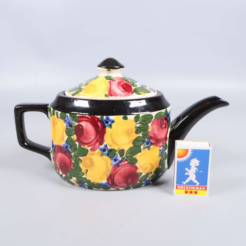 Tekanna bredvid tändsticksask för storleksreferens