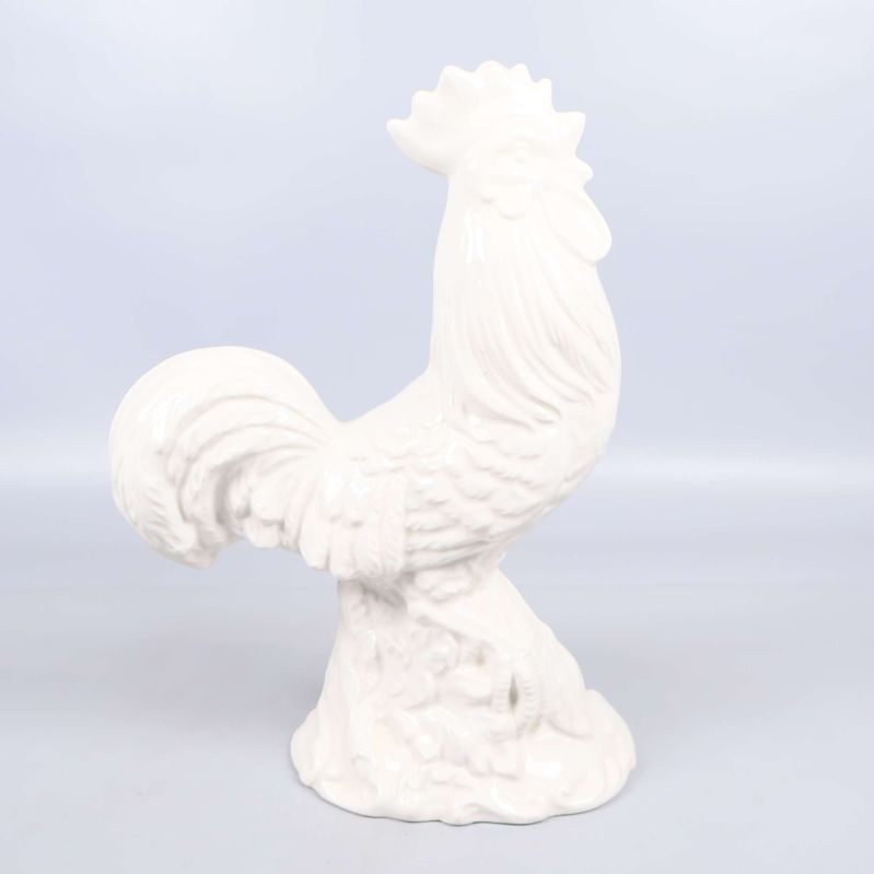 Vit tuppfigur i keramik fotograferad från andra sidan