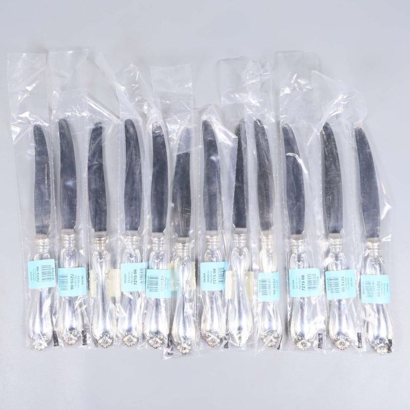 Tolv förpackade knivar med dekorativa handtag i plastpåsar