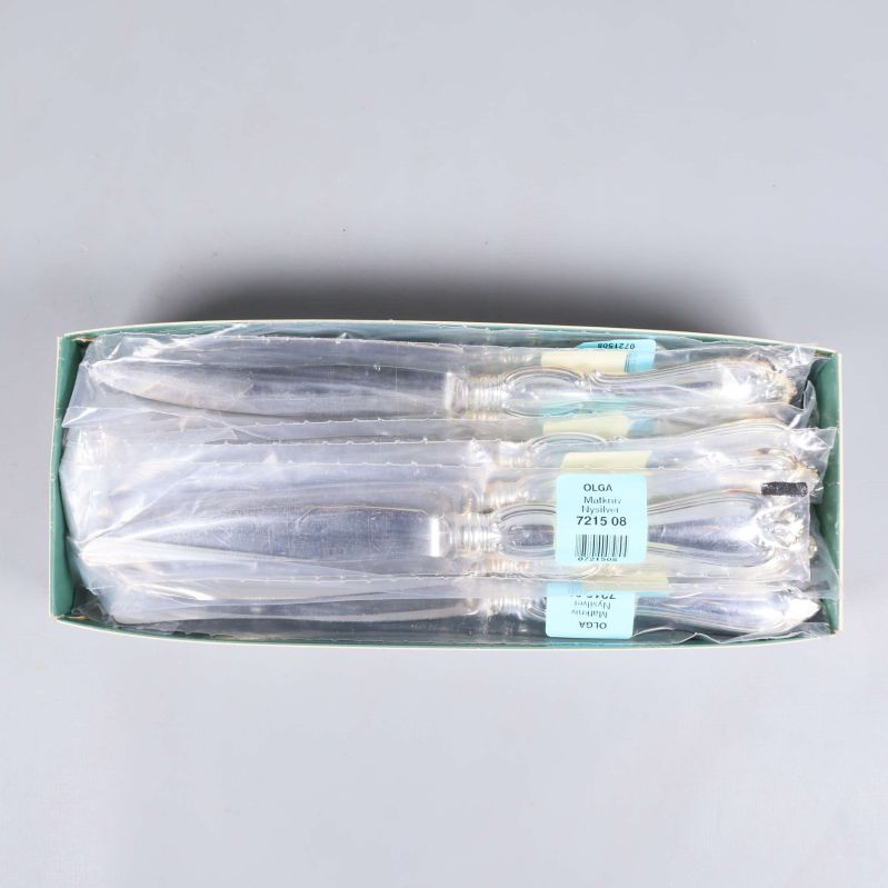 Besticksetet uppställt i en öppen grön kartong