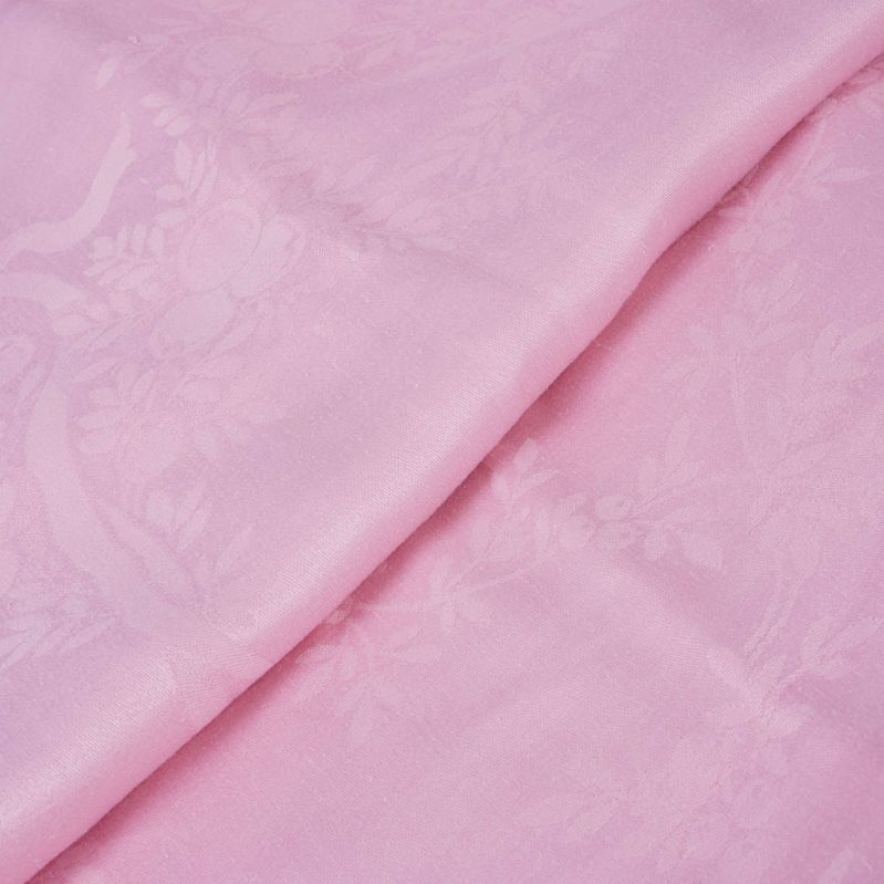 Närbild på ljusrosa duk med blommor och rosetter