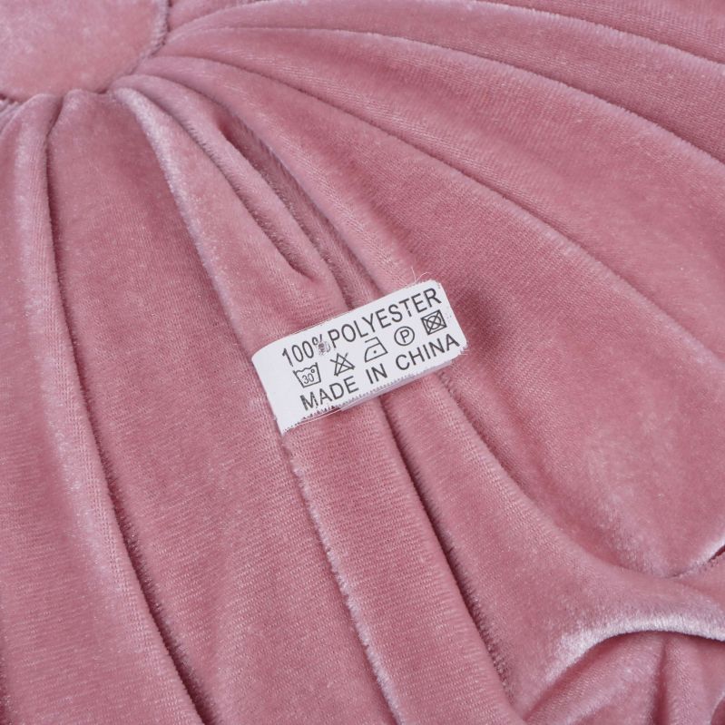 Materialetikett som visar 100% polyester på rosa kudde