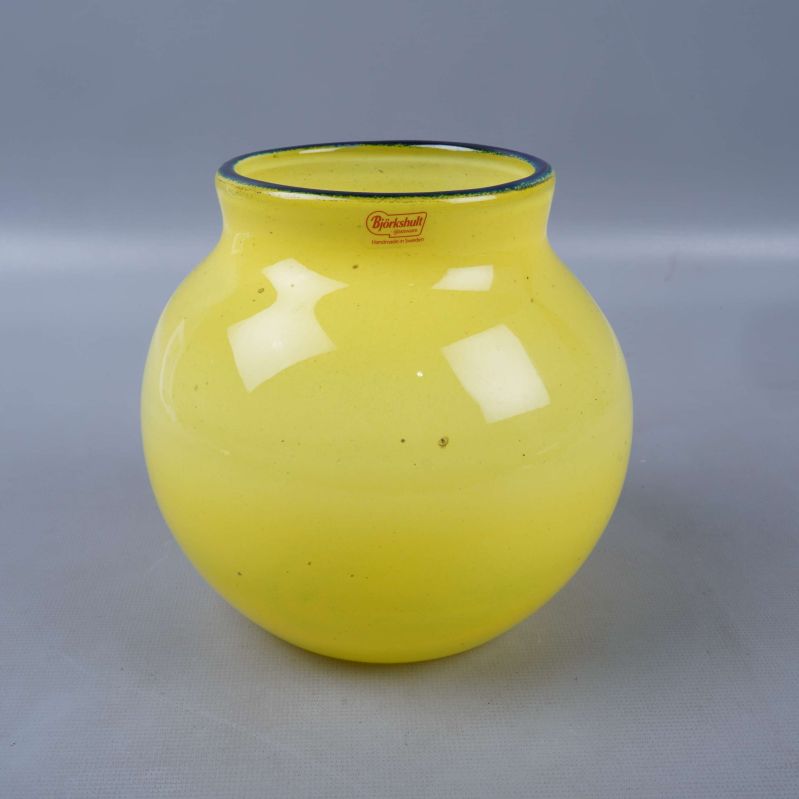 Gul vas i glas med blå kant och små prickar