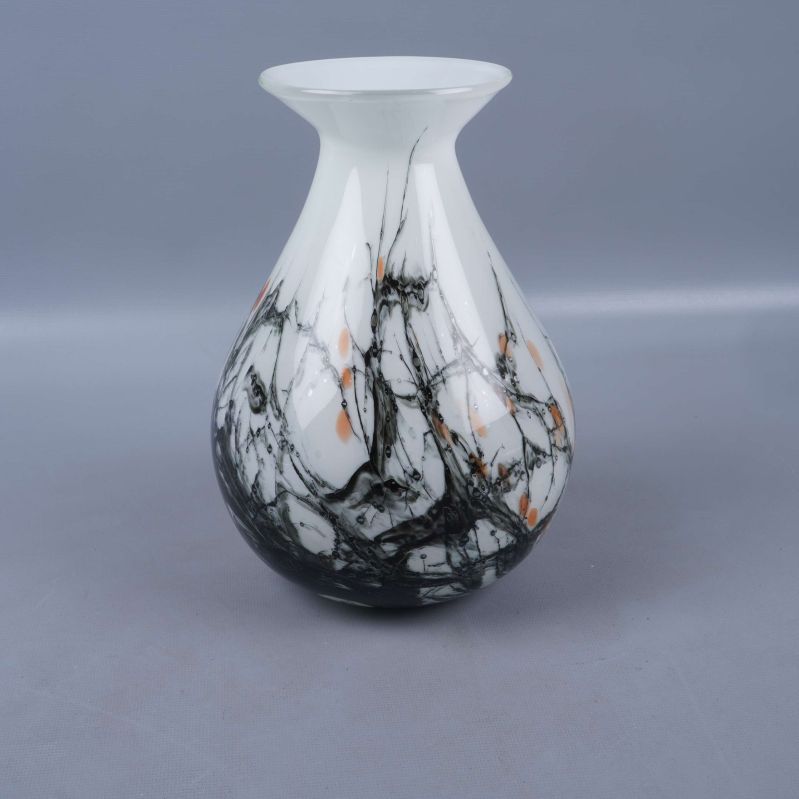 Baksidan av glasvas med svart och orange marmormönster synlig