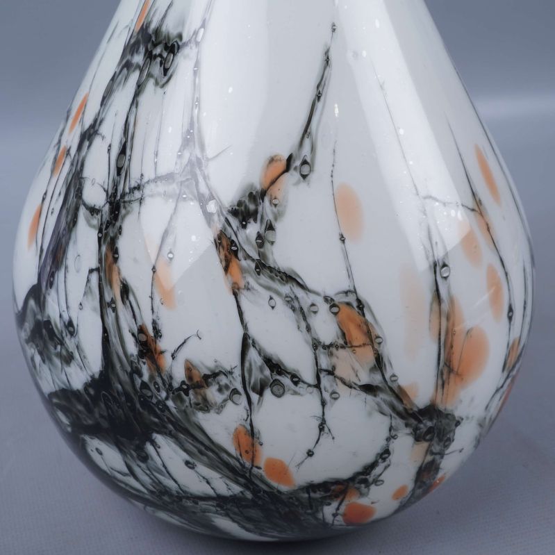 Närbild på vasen som visar svart och orange marmormönster