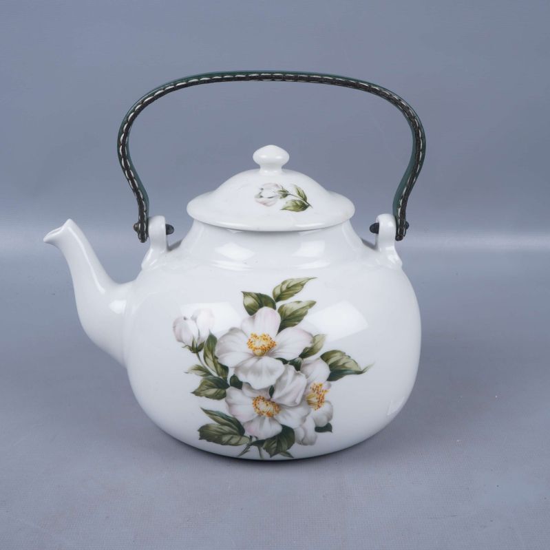 Tekanna i porslin med grönt handtag och blommönster