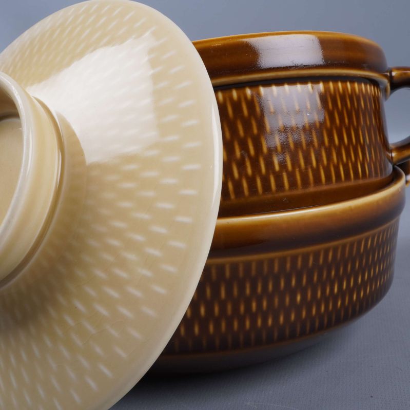 Närbild på mönstrad utsida och krämfärgat lock till skålarna