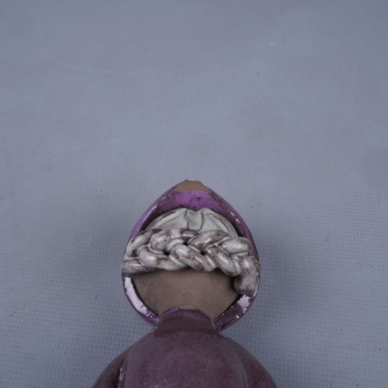 Närbild på skador och detalj upptill på porslinsfiguren