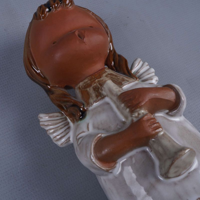 Närbild av ängelns hand och trumpet