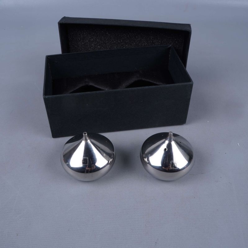 Två runda kryddströare bredvid svart ask