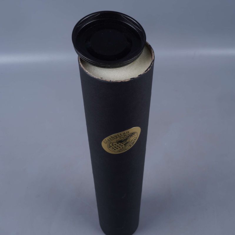 Öppen svart förpackningstub med lock bredvid