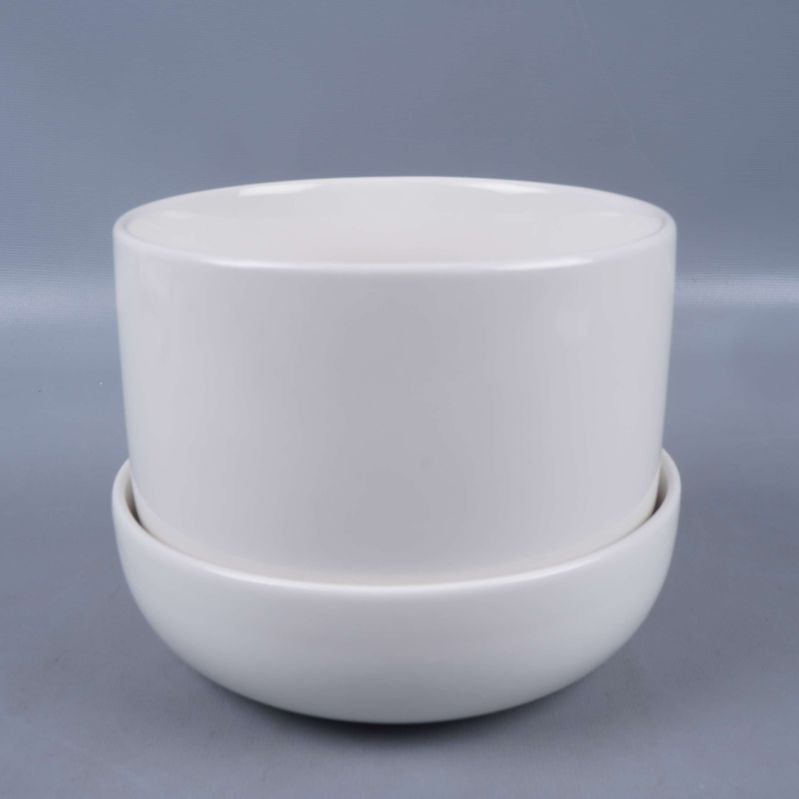 Vit rund kruka på fat fotograferad framifrån