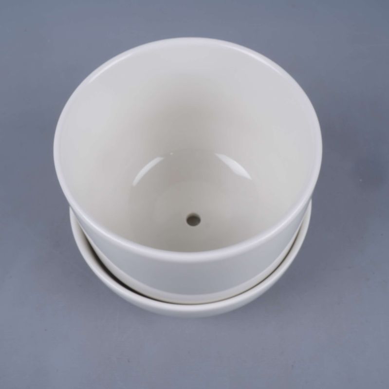 Ovanifrån på öppen ytterkruka med avrinningshål och fat