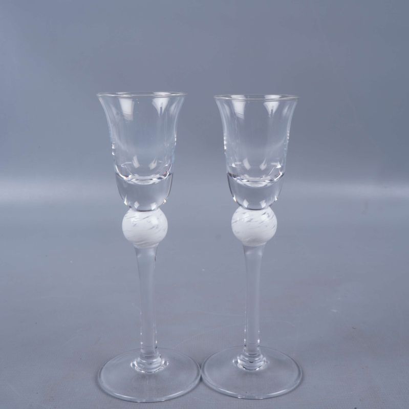 Två höga glas med vit kulfot från sidan