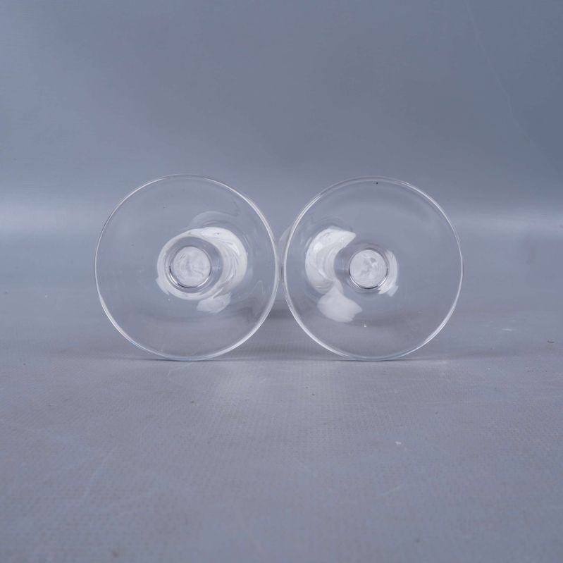 Botten av två glas med genomskinlig fot och dekorativ kula