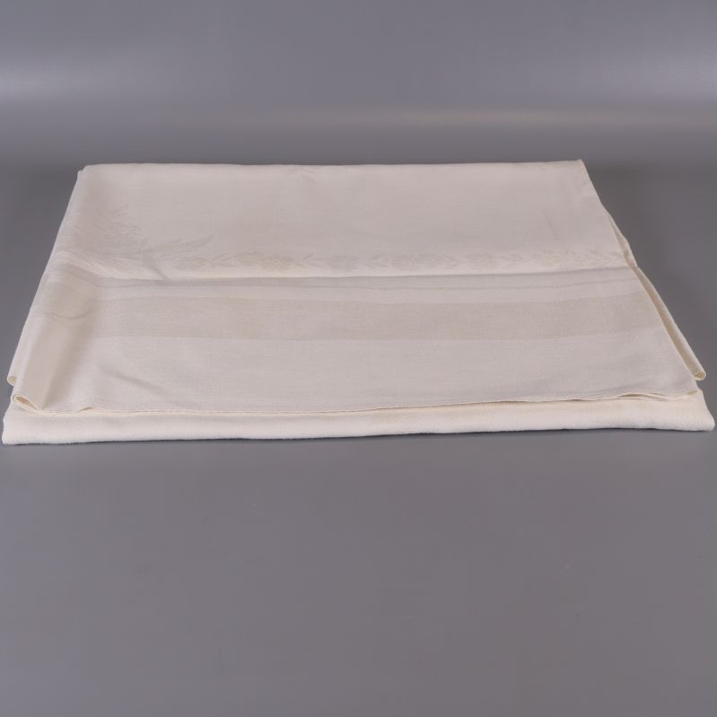 Ljus bordduk vikt ut med vävt mönster synligt