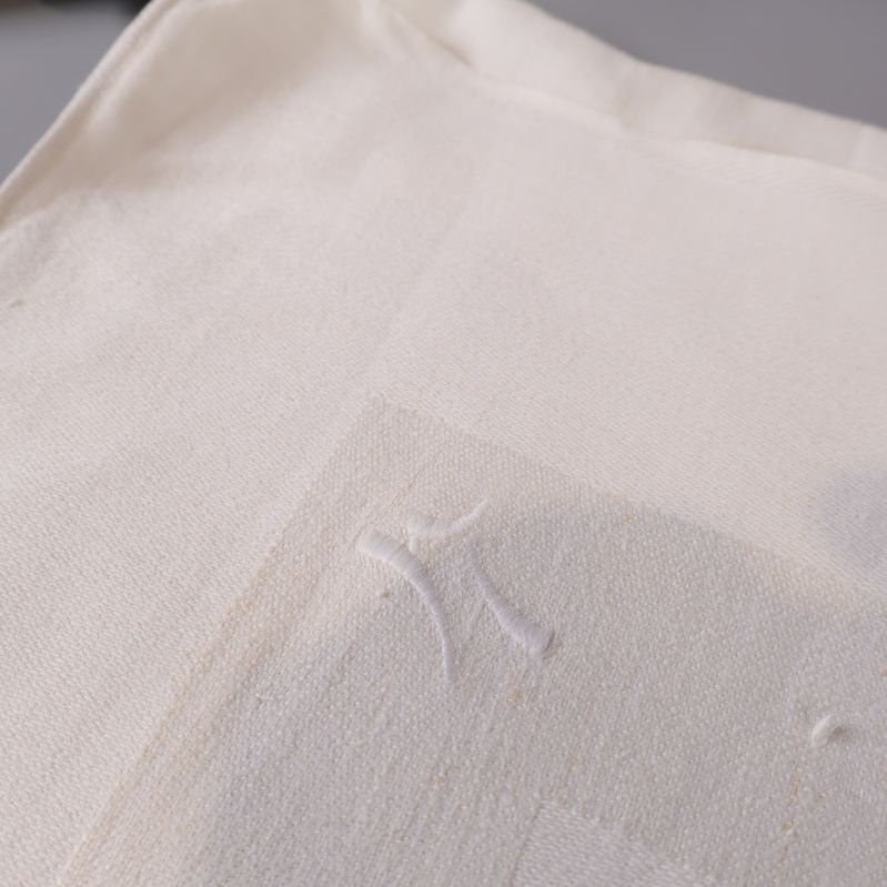 Närbild på hörn av duken med monogram 