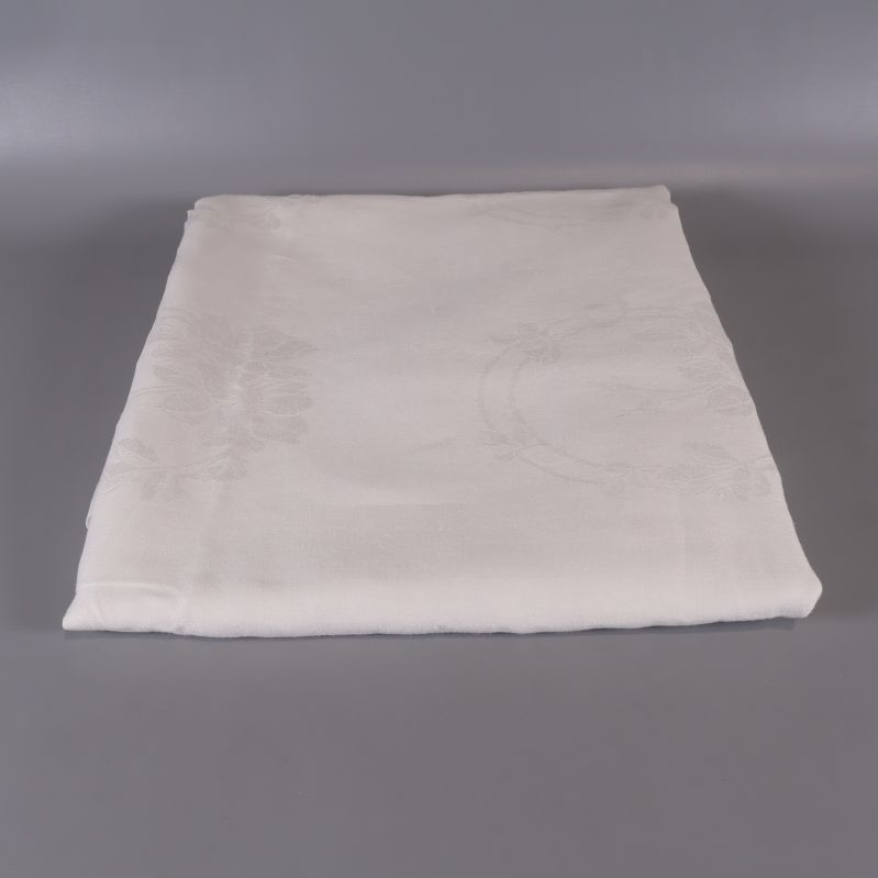 Vikta vit duk med diskret blommönster på grå bakgrund