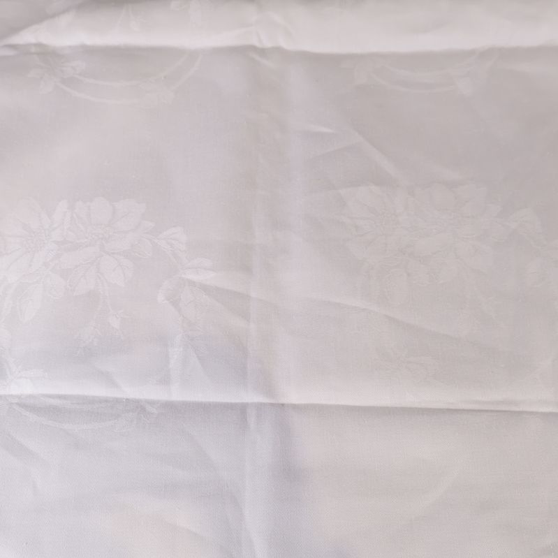 Bordsduk med subtila blommönster i tygstrukturen