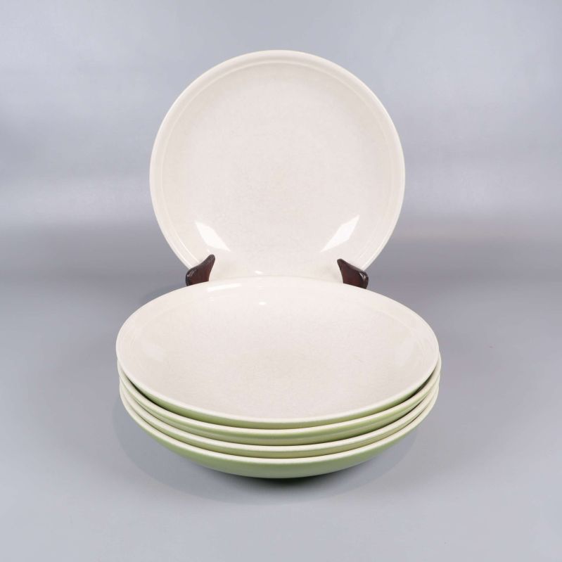 Fem djupa tallrikar med ljus insida och grön utsida