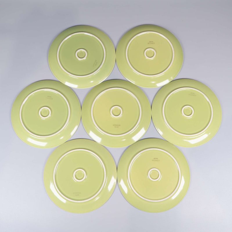 Sju gröna tallrikar vända med baksidan uppåt