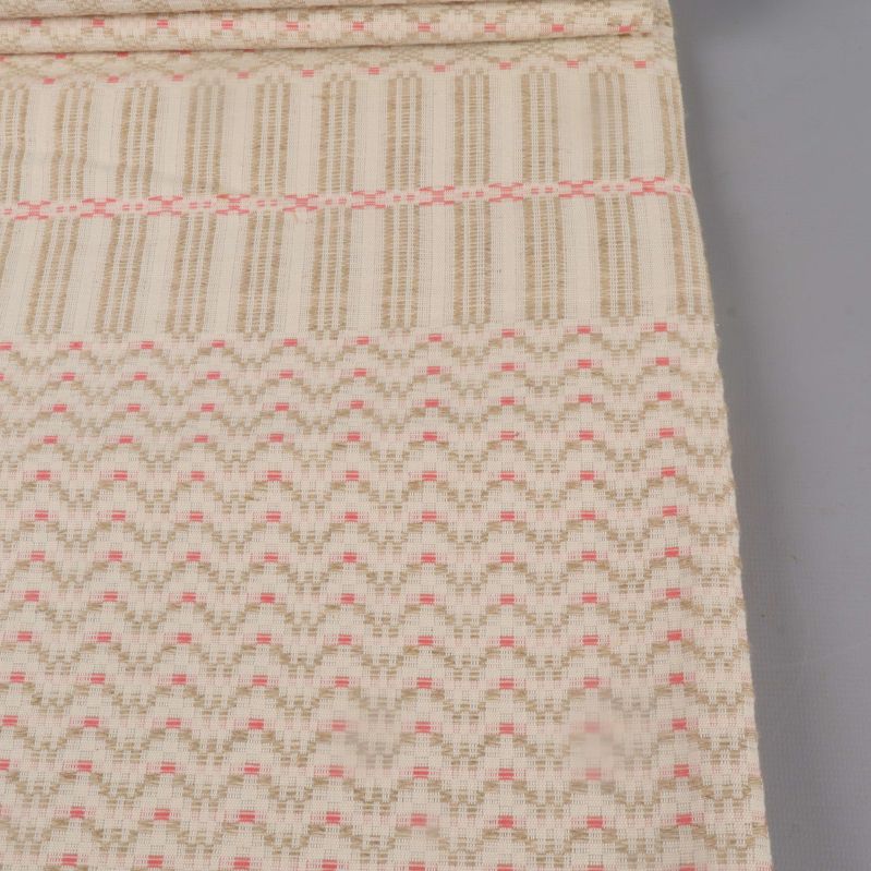 Närbild på dukens grafiska mönster i rosa och beige