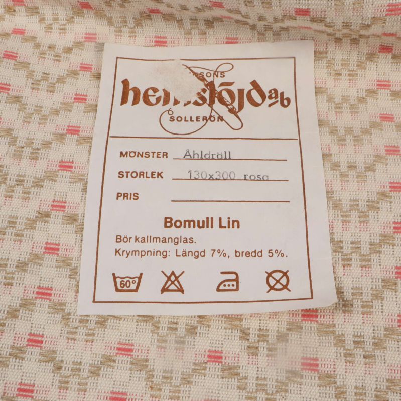 Närbild på originaletikett med skötselråd och materialinfo