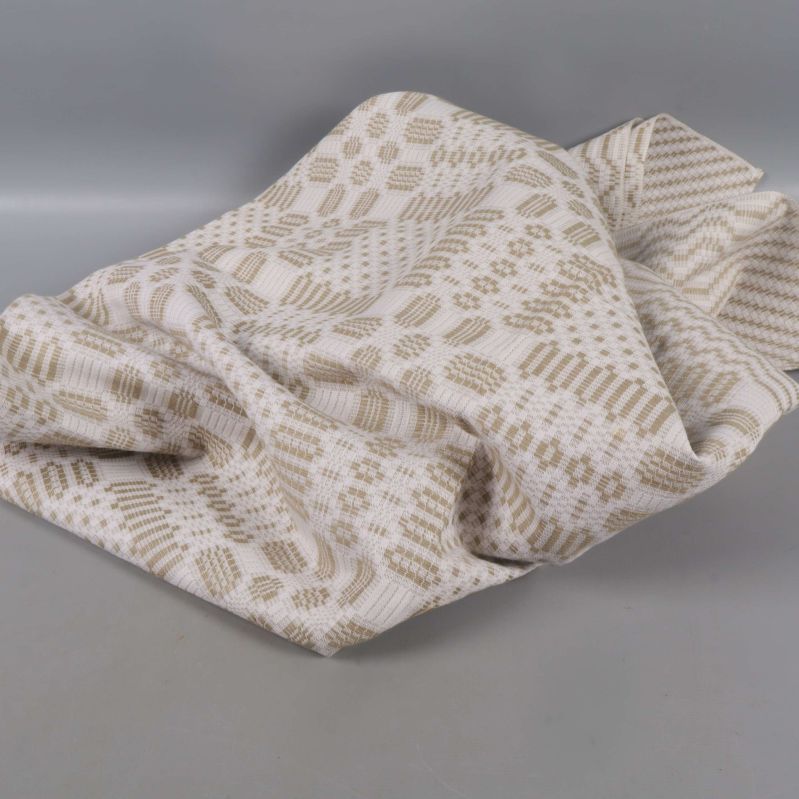 Slarvigt vikt beigevit duk med geometriskt mönster