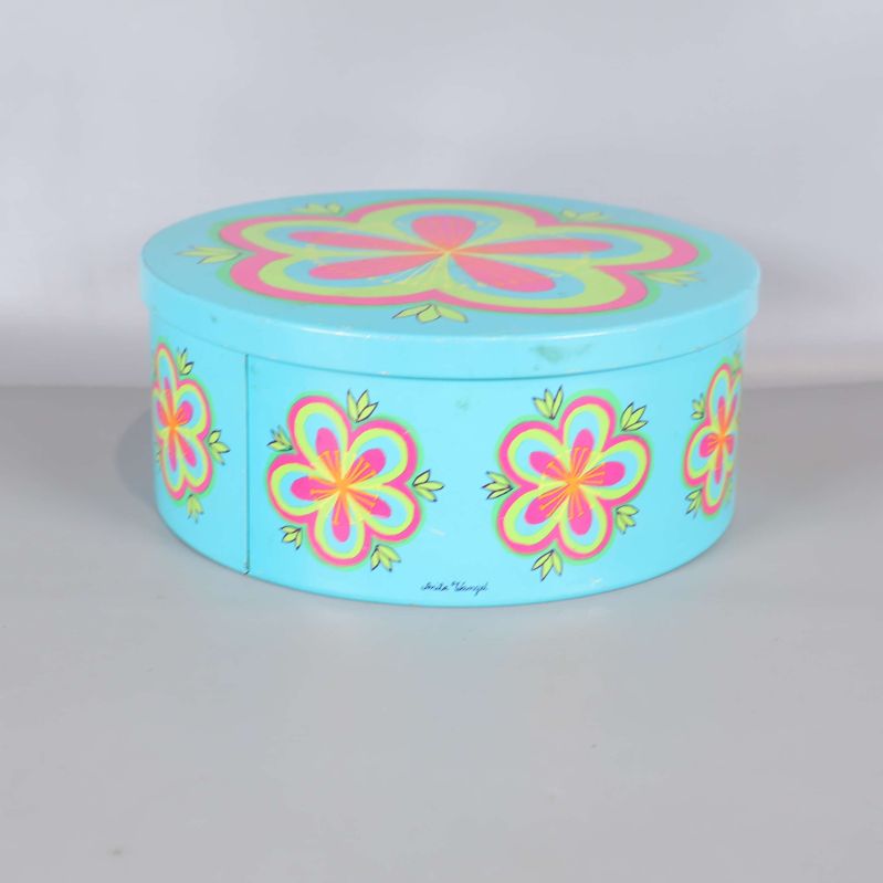 Turkos burk med blommönster sedd från sidan