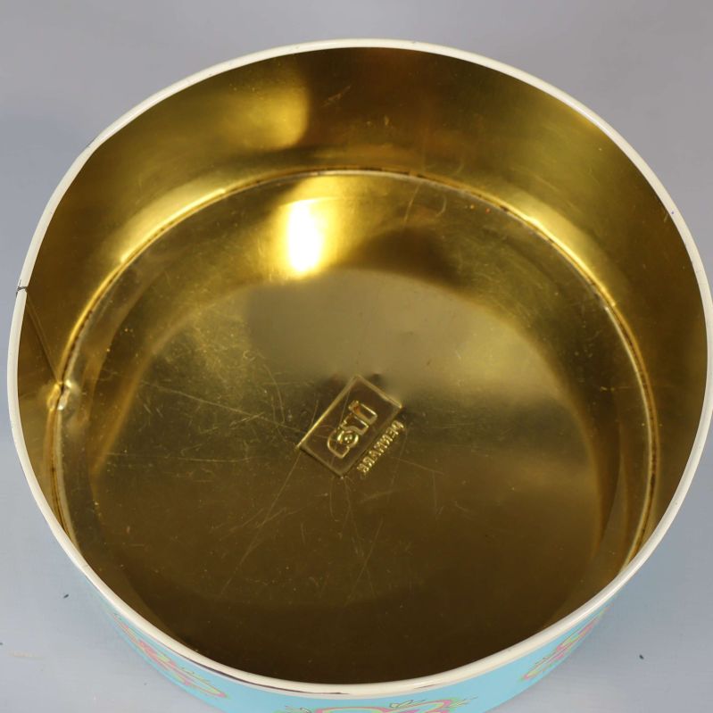 Insida av burk med guldig metallfinish och präglad logotyp