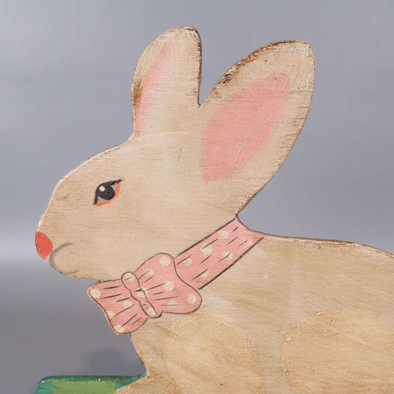 Närbild på kaninens huvud och rosett i trä