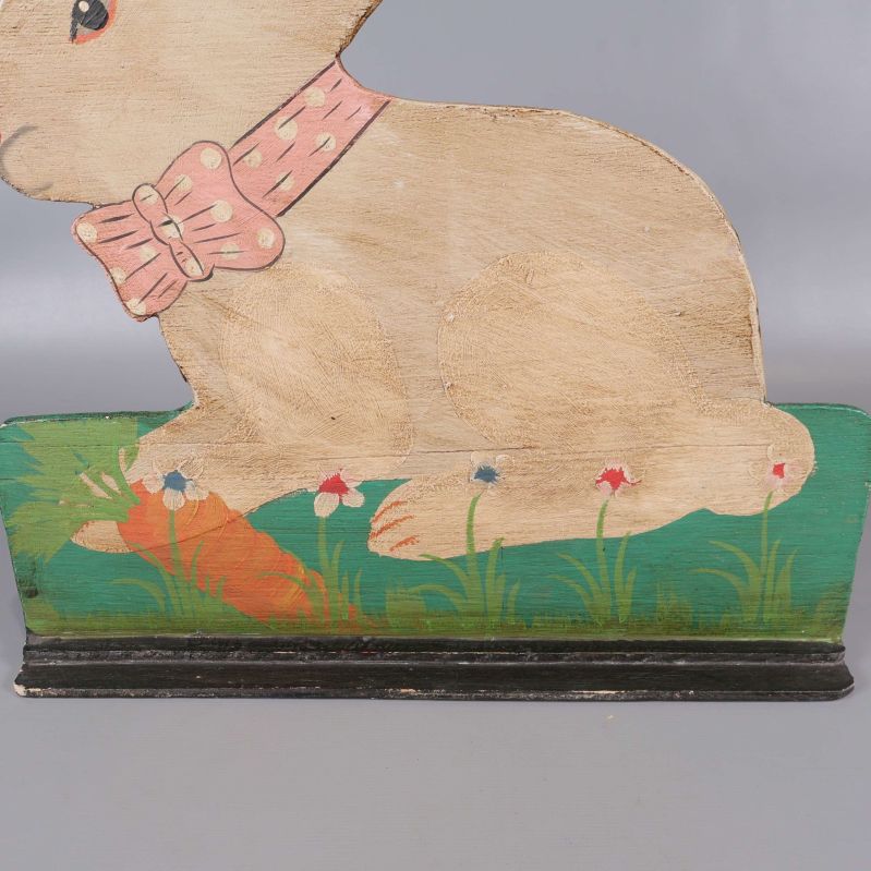 Närbild på kaninens ben och färgglad bas med morot