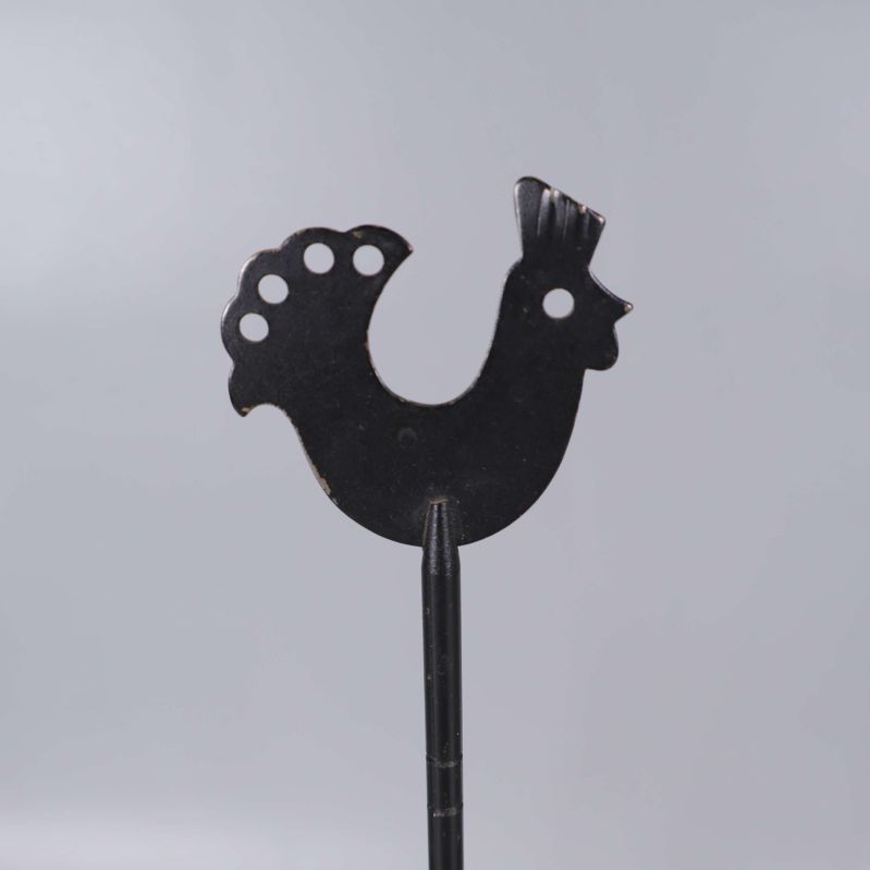 Detaljerad närbild av tuppmotivet högst upp