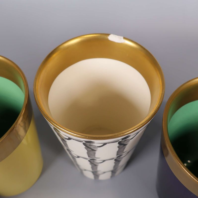Närbild på mönstrad bägare med guldkant och ljus insida