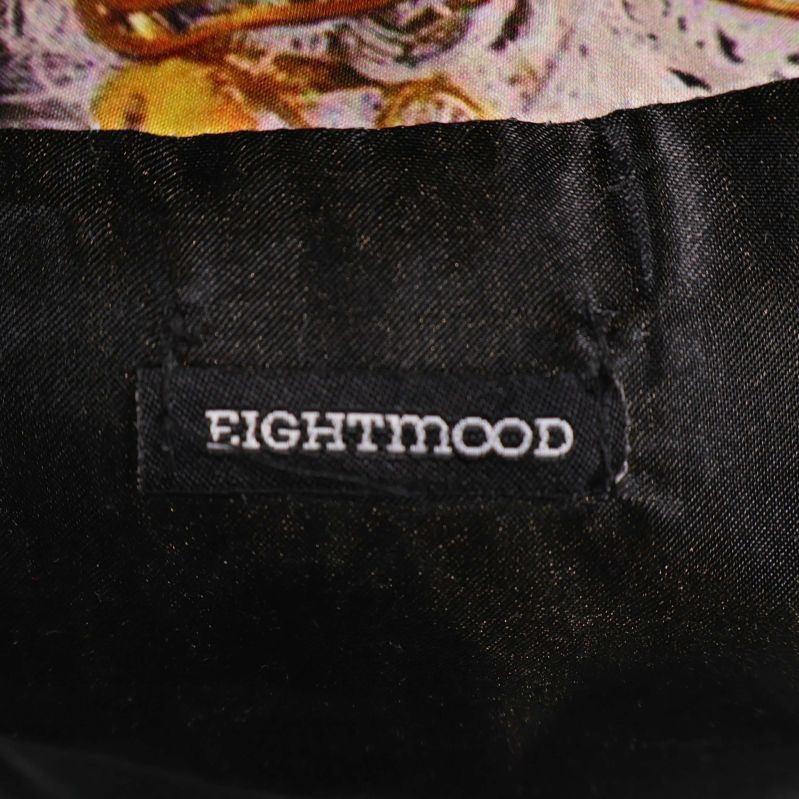 Svart etikett med texten EIGHTMOOD på kudde