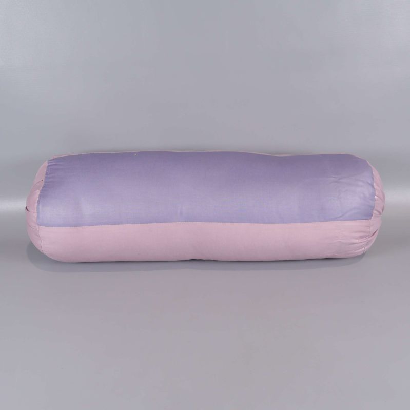 Cylindrisk kudde i ljust lila och rosa liggandes på golv