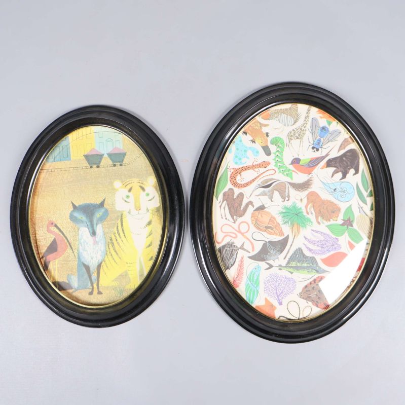 Två mindre ovala svarta ramar med djurmotiv