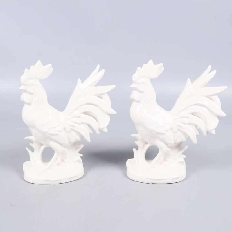 Två vita tuppfigurer med detaljerad fjäderdräkt