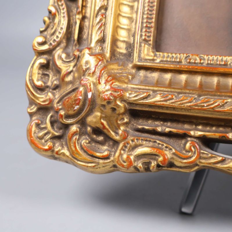 Närbild på hörn av guldram med detaljerad ornamentik