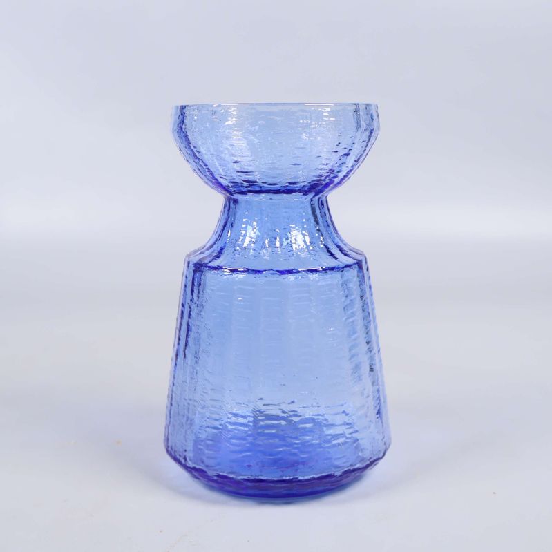 Blå glasvas med strukturyta fotad framifrån