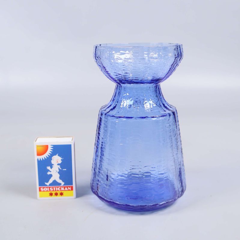 Blå strukturerad vas bredvid tändsticksask