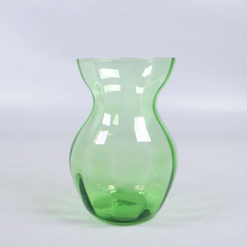 Grön vas i transparant glas på vit bakgrund