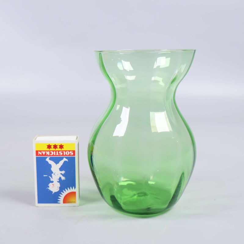 Grön glasvas jämte tändsticksask för storleksjämförelse