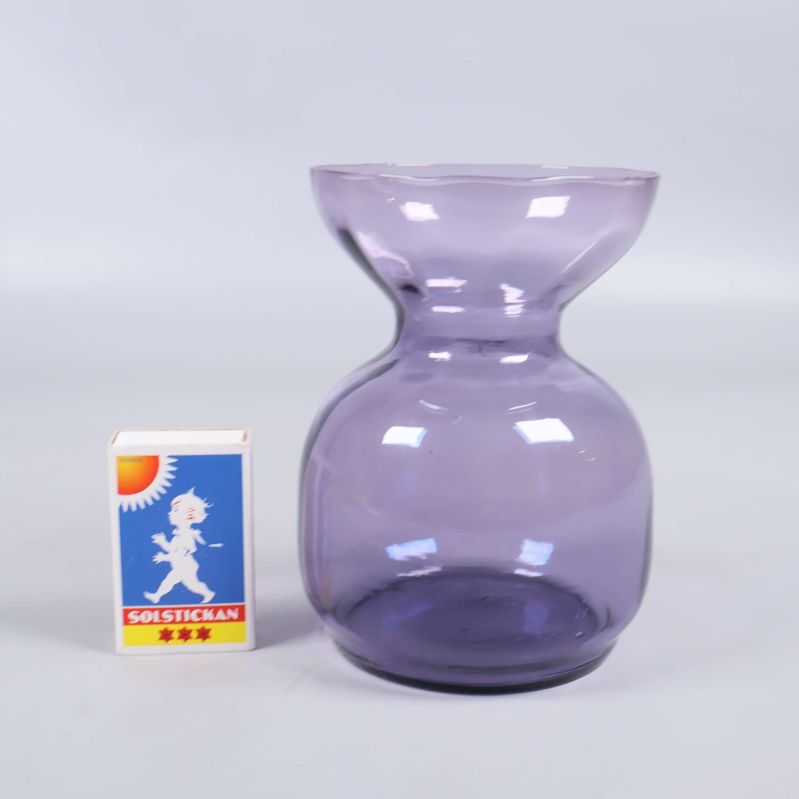 Blå glasvas jämte tändsticksask för storleksjämförelse