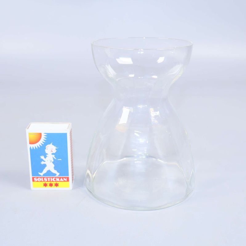 Transparent vas jämte tändsticksask för storleksreferens