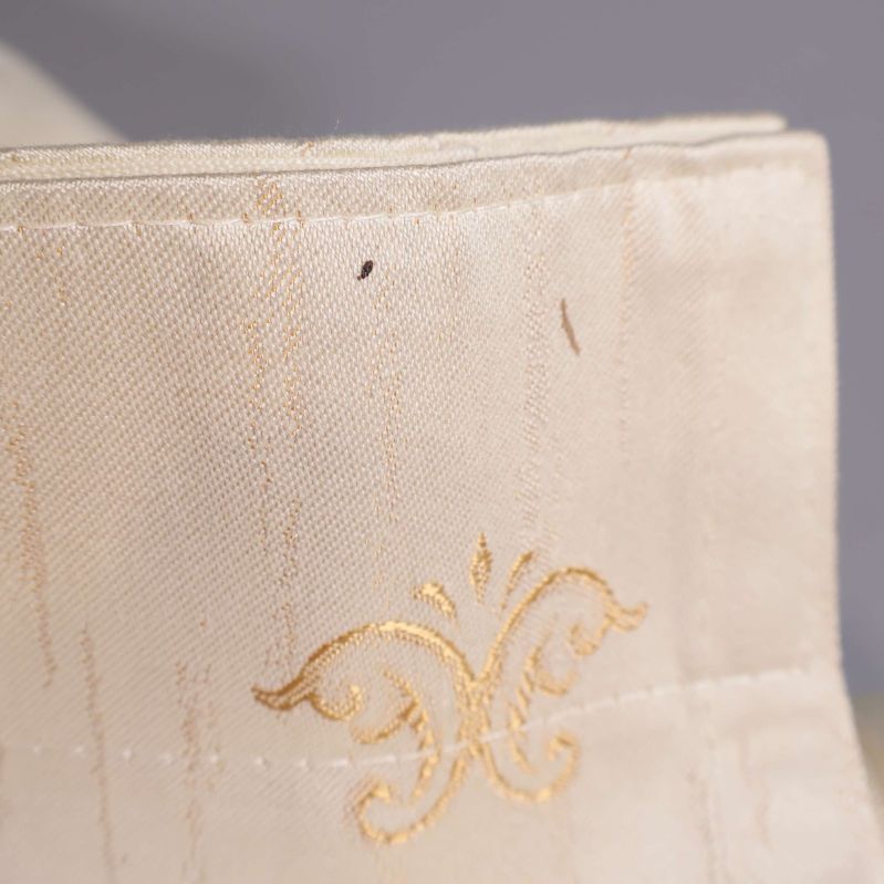 Gardinkant med guldmönster och liten mörk prick