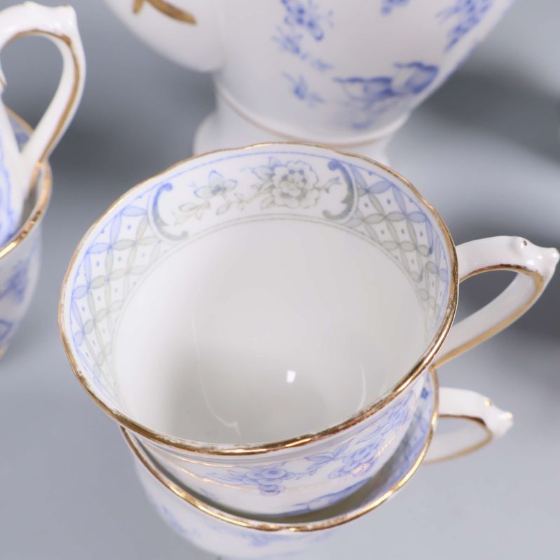 Närbild på blåvit kopp med gulddekor