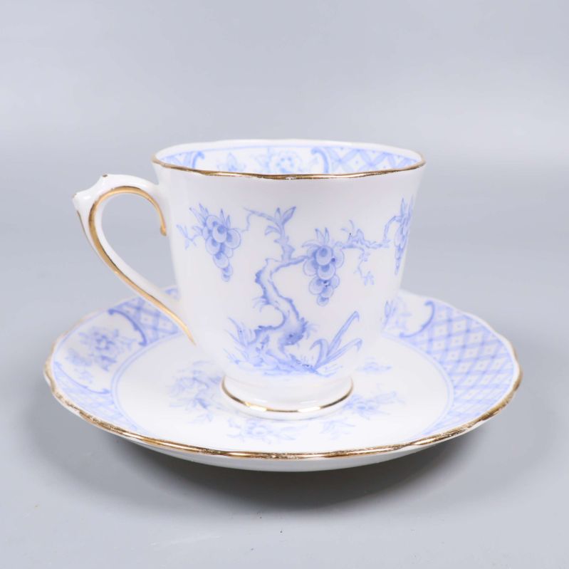 Tekopp med assiett i blåvitt porslin och guldkant